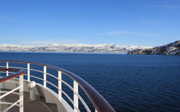 Schiffsreling eines Kreuzfahrtschiffes mit Ausblick auf das Meer, Gestein und Eis
